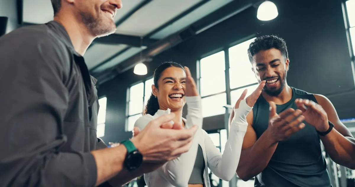 Three colleagues laughing together after a training session.