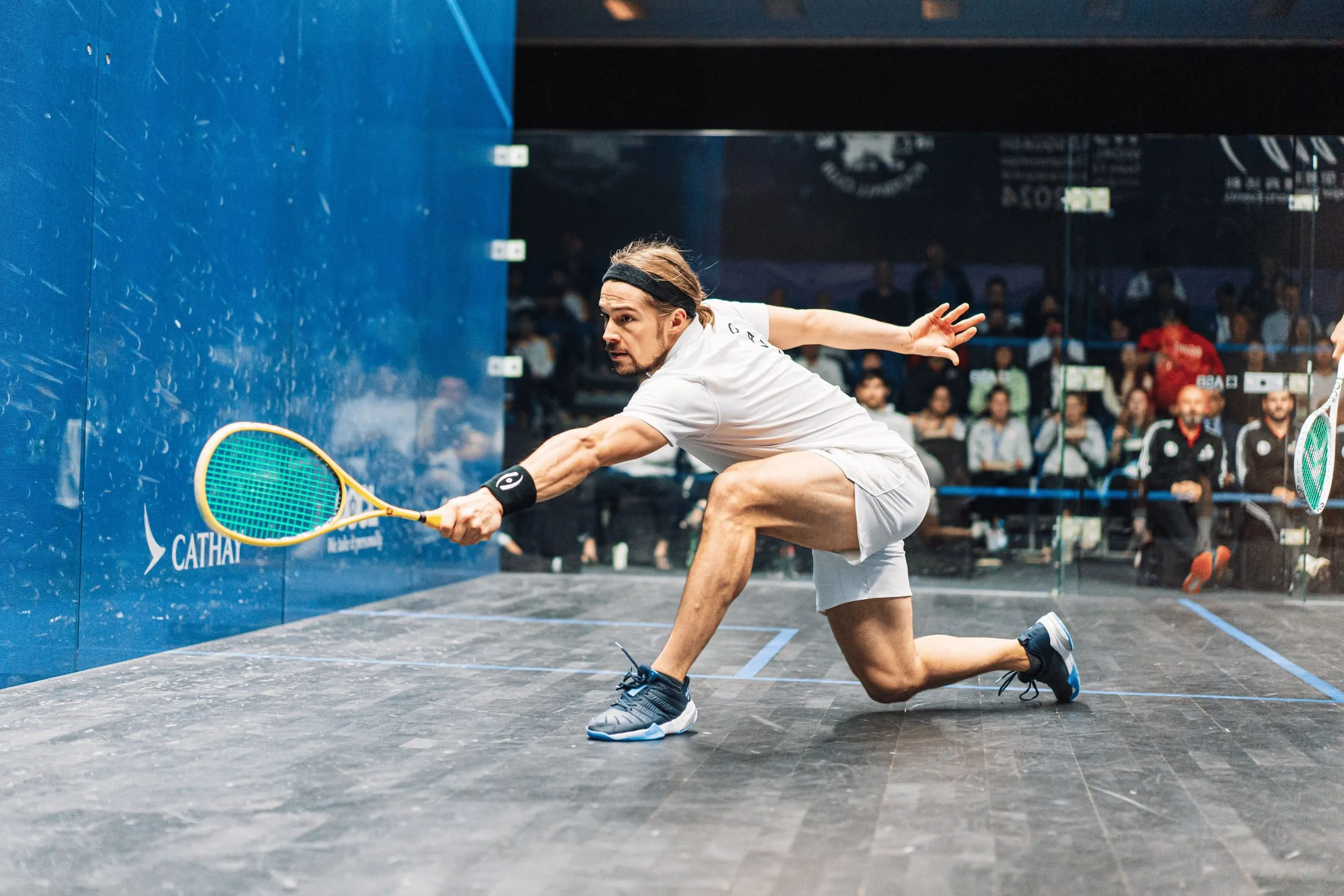 David Baillargeon, the club's ambassador, lunging deep to reach the ball on court.