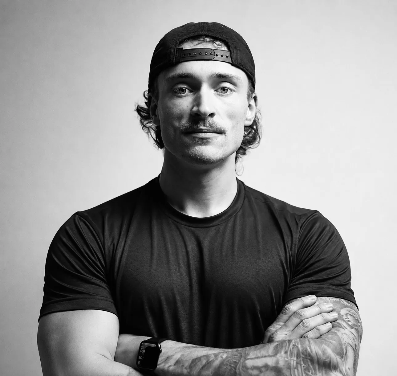 Portrait en noir et blanc d’Olivier Larocque, bras croisés, casquette à l’envers.